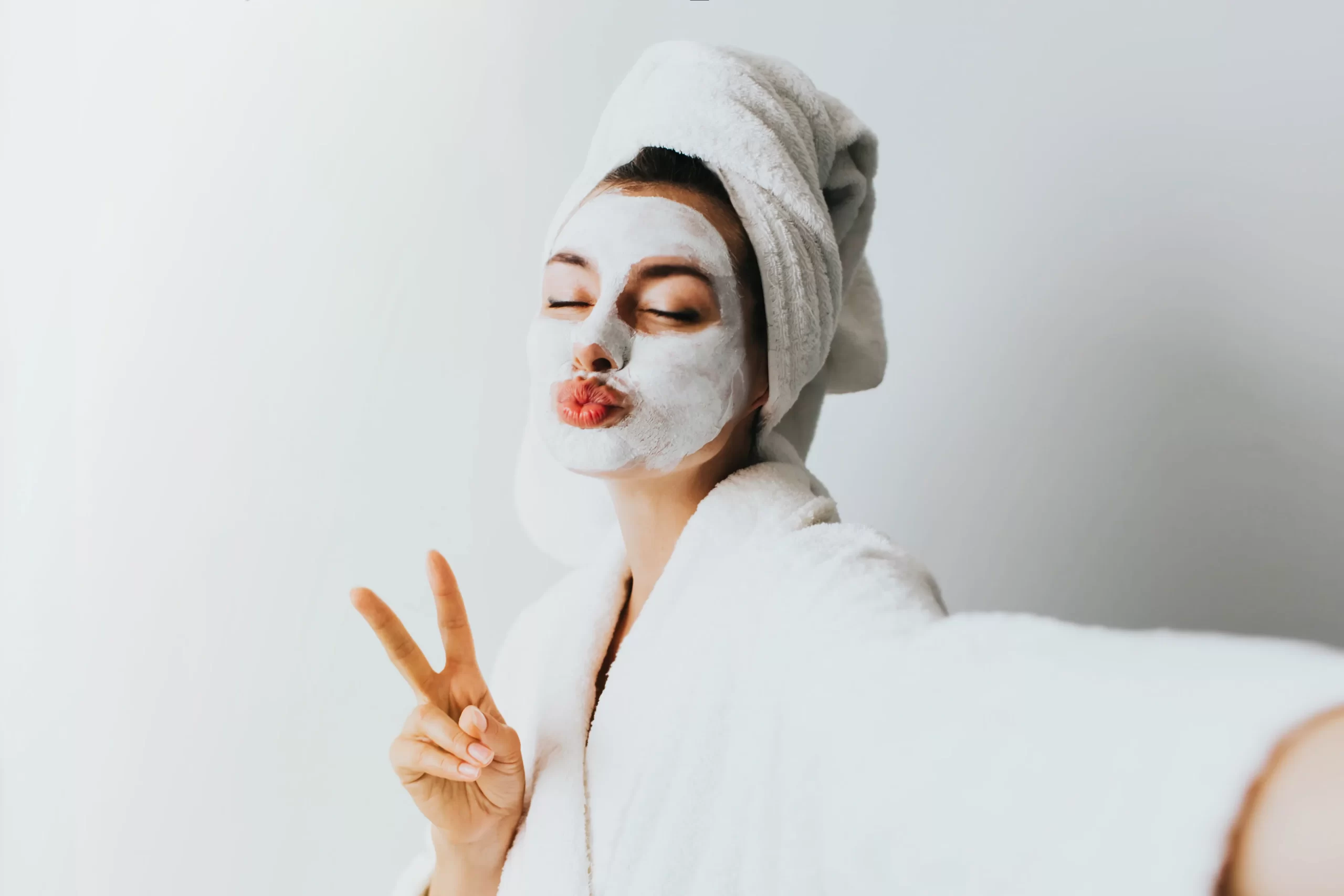 Woman applying facial oil drops onto her clean glowing skin as part of a nighttime skincare routine