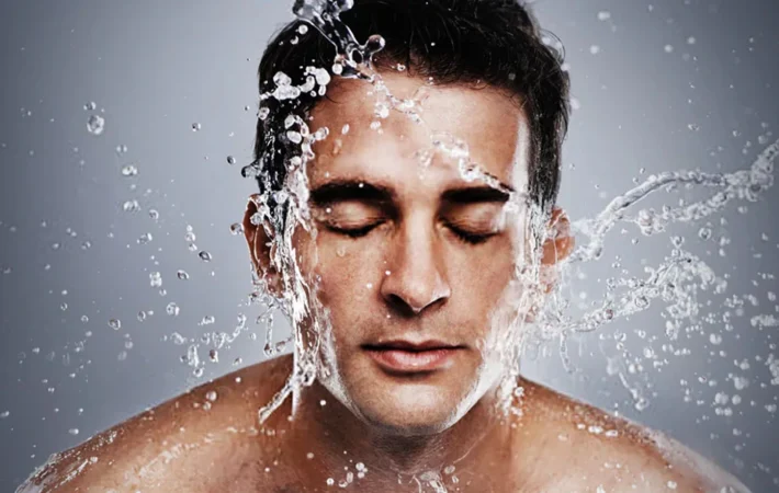 man applying moisturizer on face as part of simple 3 step skincare routine for men